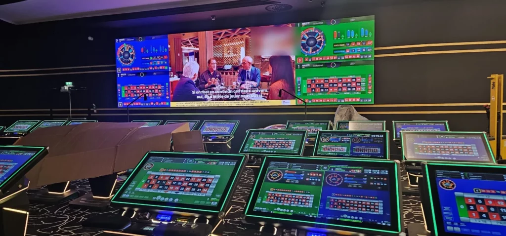 Grand mur d'écran LED affichant plusieurs contenus au-dessus de bornes de jeux
