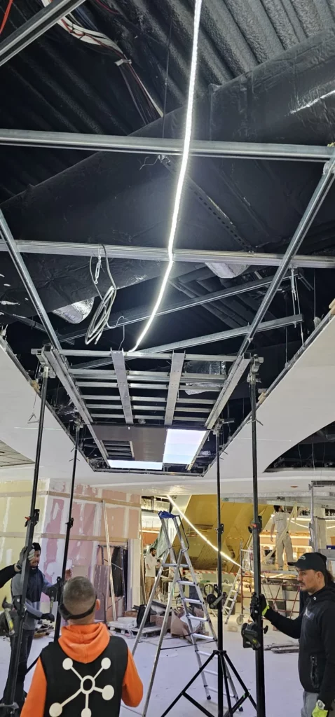 Structure métallique et premières dalles d'un plafond écran LED pendant le levage